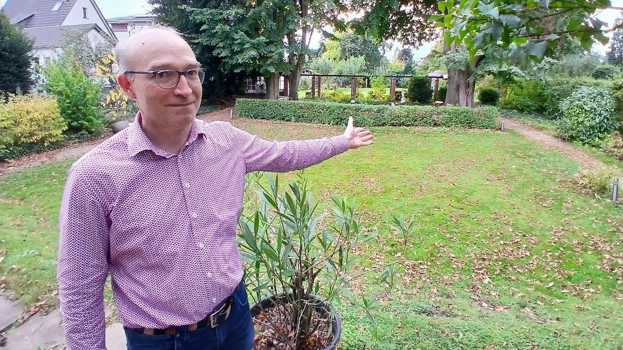 Ein Mann zeigt in seinen Garten