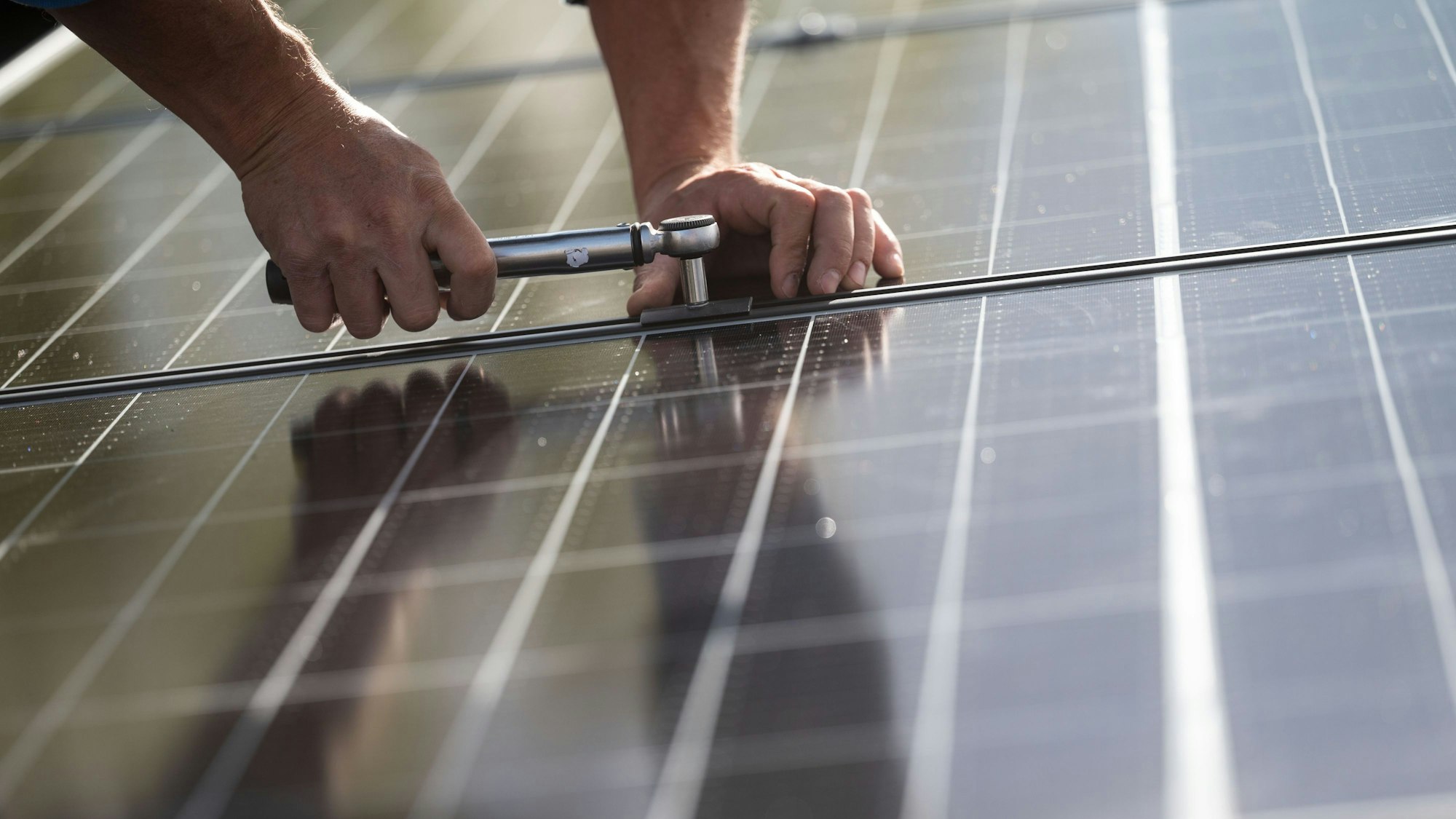 Ein Handwerker montiert ein Solarmodul.