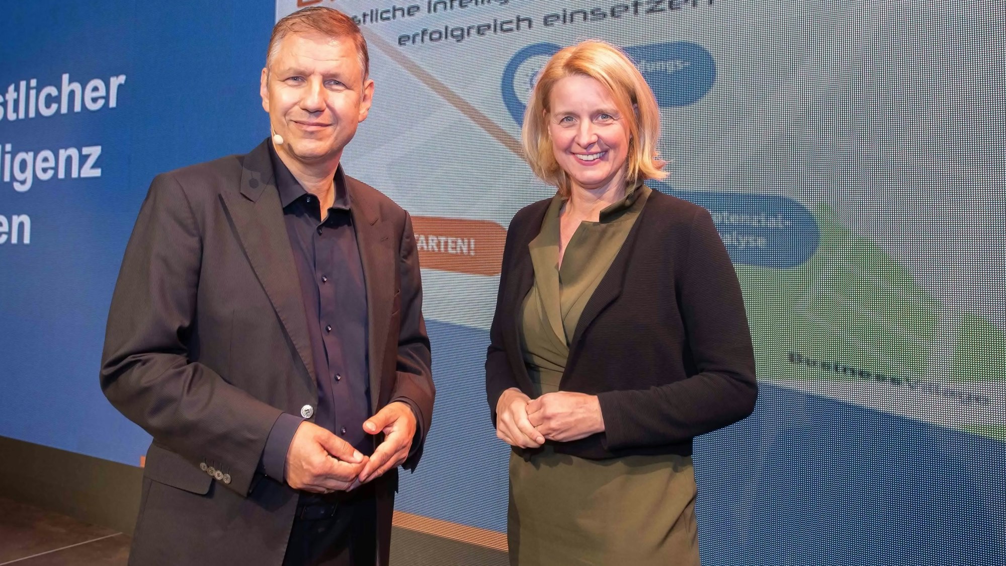 Eine Frau und ein Mann stehen vor einer Präsentationswand