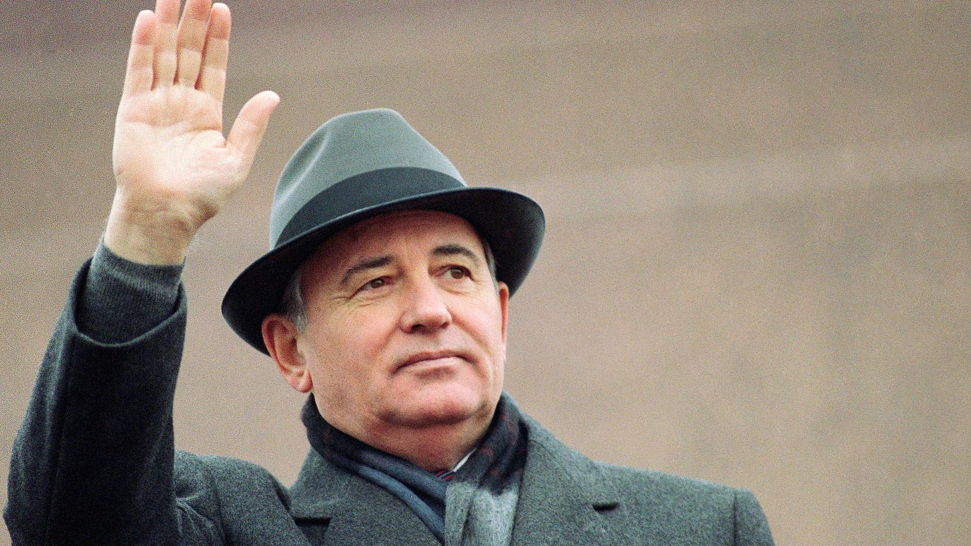 Michail Gorbatschow, damals sowjetischer Präsident, winkt 1989 von der Tribüne des Roten Platzes während einer Feier zum Tag der Revolution.