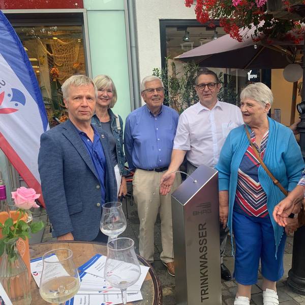 Eine Gruppe von Menschen an einem Trinkwasserspender.