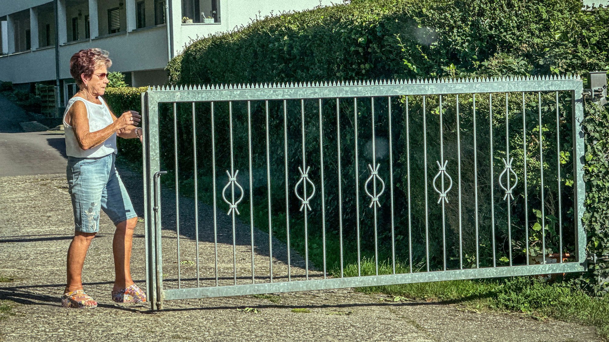 Trudi Decker schiebt ein Tor zu, damit niemand auf den Campingplatz kommt.