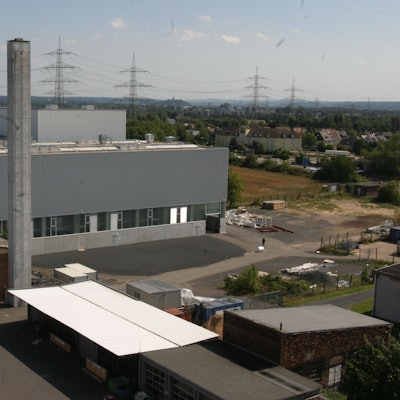 Ein Gewerbebau mit hohem Schornstein.