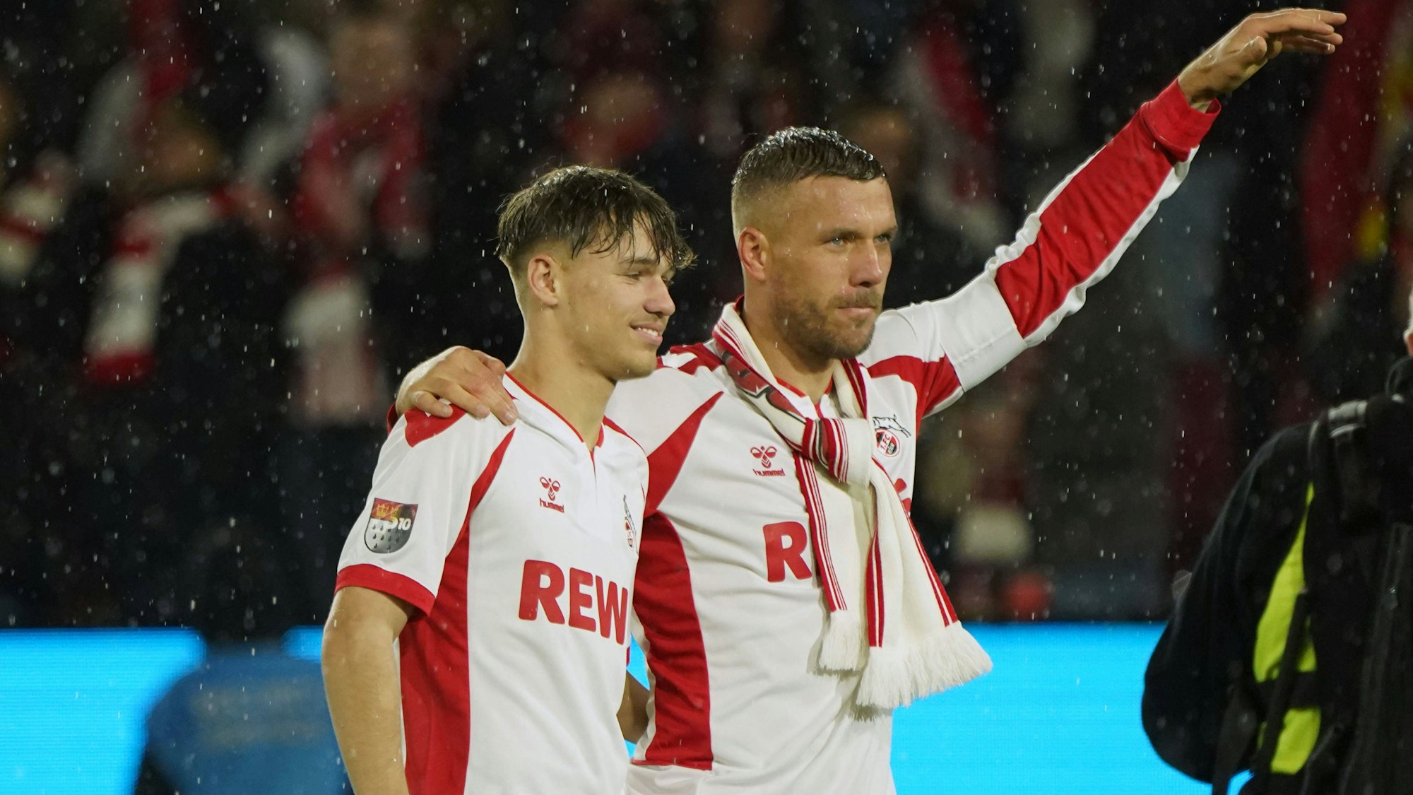 Ein seltenes Bild: Lukas Podolski steht zusammen mit Sohn Louis auf dem Rasen von Müngersdorf. Beim Abschiedsspiel in Köln spielten Vater und Sohn auch einige Minuten zusammen im FC-Sturm.