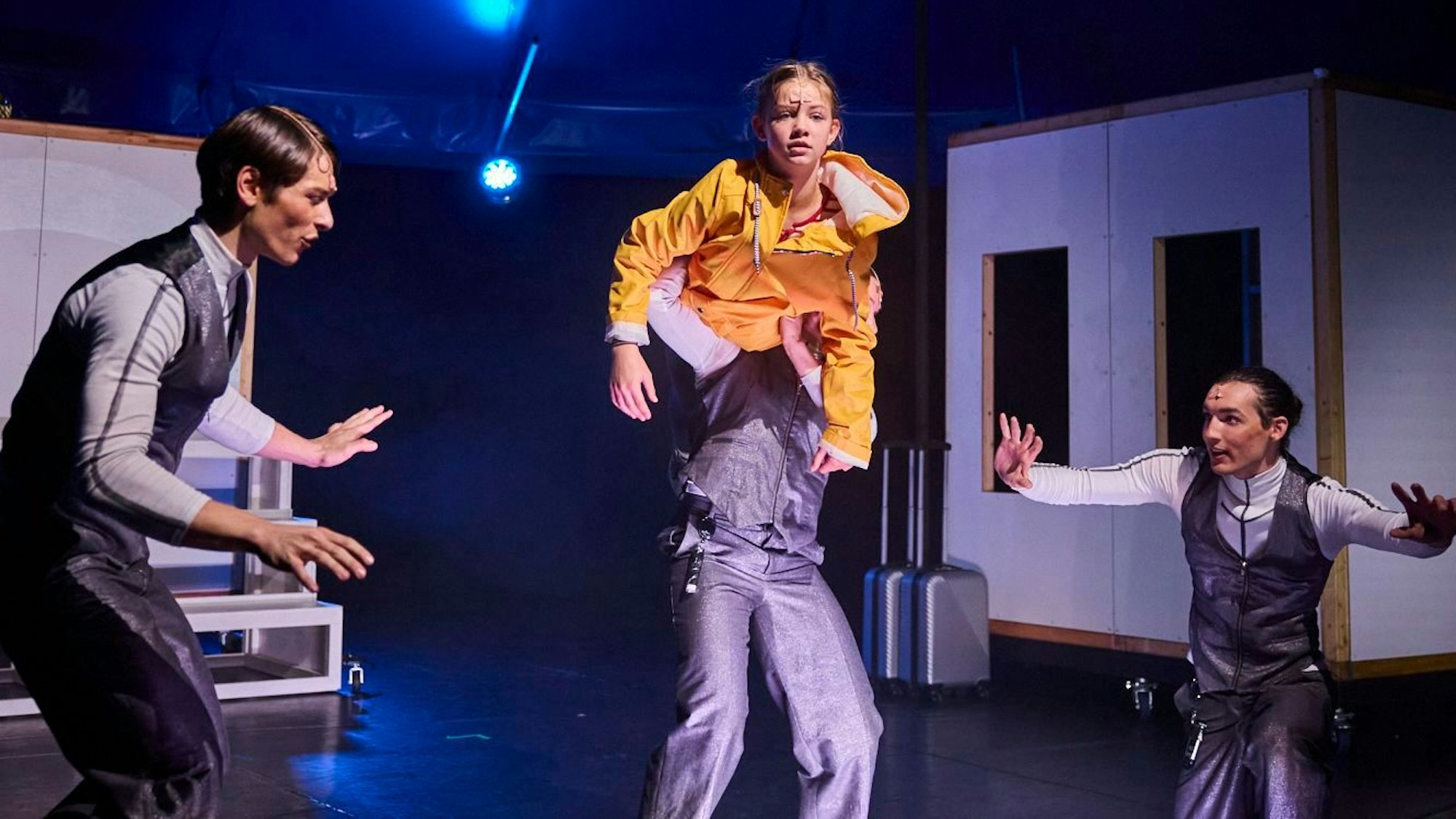 Momo, im gelben Regenmantel, versucht den drei Grauen Herren zu entfliehen.