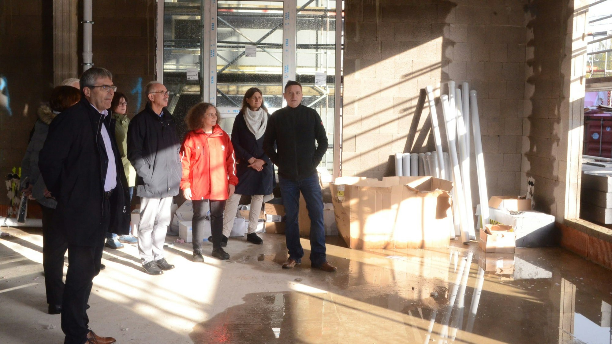 Männer und Frauen stehen auf einer Baustelle.