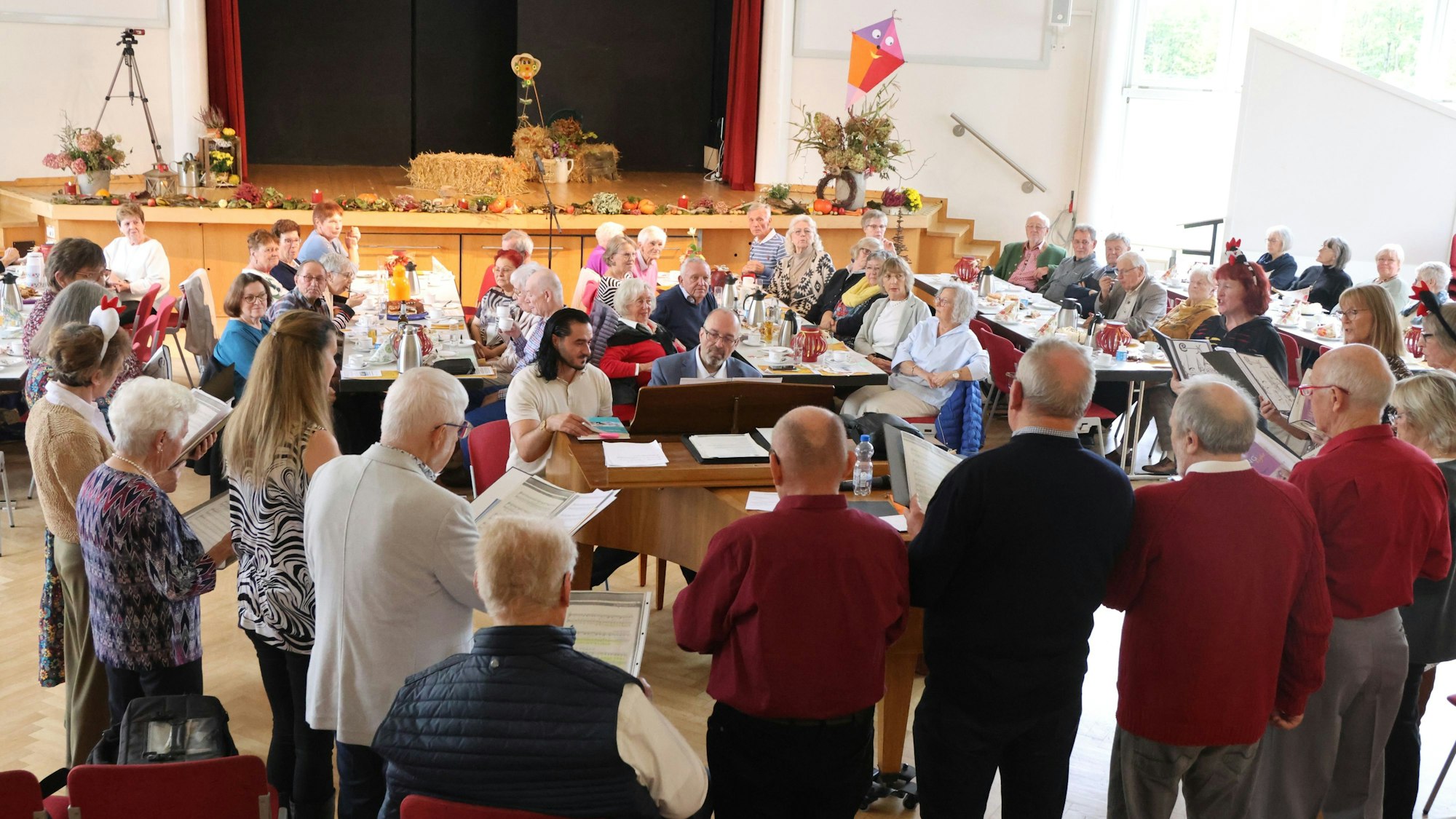 Ein Chor singt vor gedeckten Tischen.