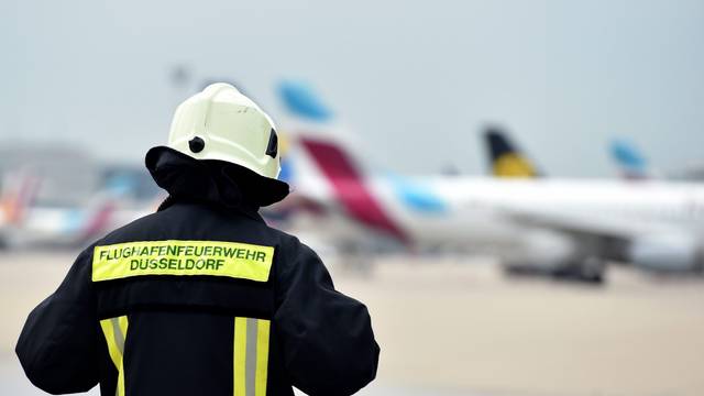 Ein Mitarbeiter der Flughafenfeuerwehr auf dem Rollfeld des Flughafens in Düsseldorf (Nordrhein-Westfalen).