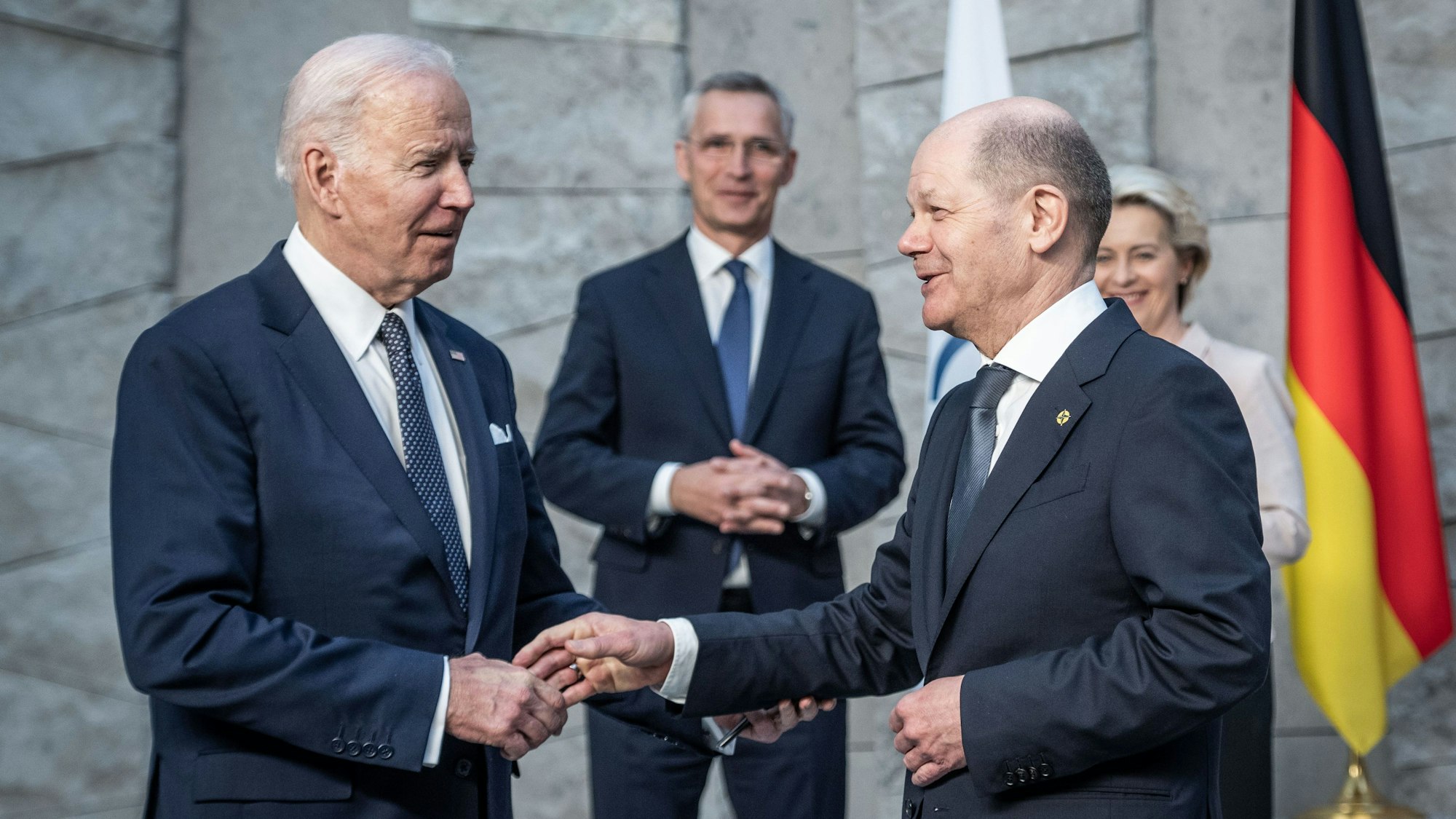 Bundeskanzler Olaf Scholz (r, SPD), begrüßt Joe Biden (l), Präsident der USA, vor Beginn des Treffens der G7-Staaten im Nato-Hauptquartier. Im Hintergrund stehen Jens Stoltenberg, Nato-Generalsekretär, und Ursula von der Leyen, Präsidentin der Europäischen Kommission. (Archivbild)