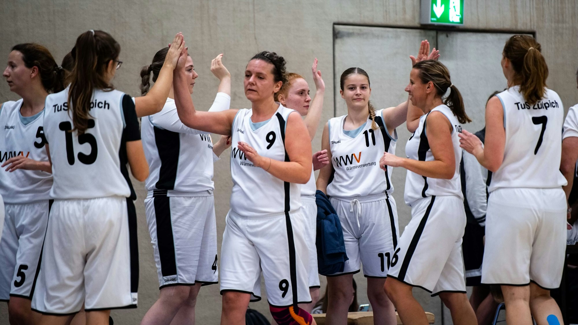 Die Spielerin klatschen sich am Spielfeldrand gegenseitig ab.