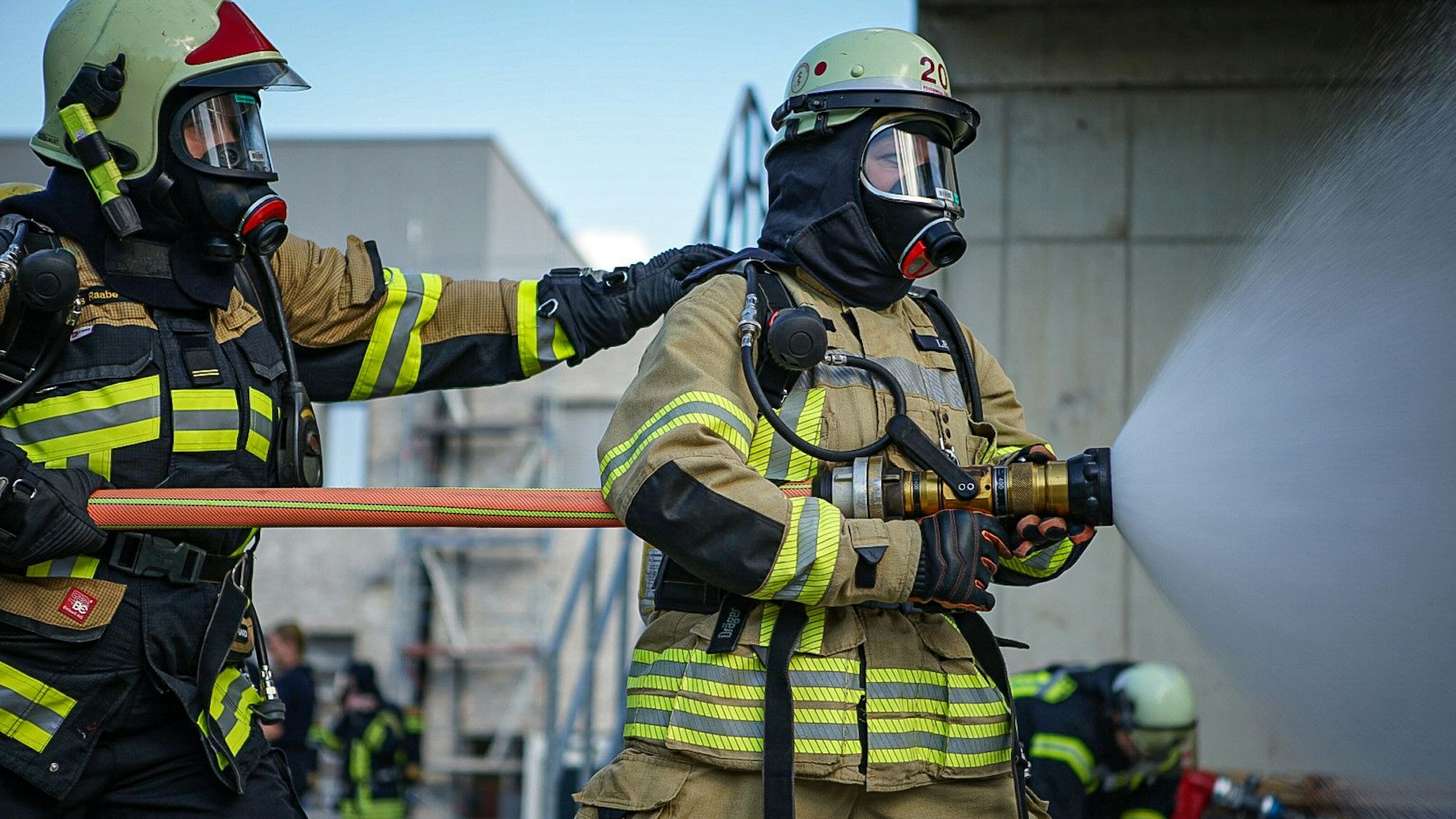 Zwei Feuerwehrfrauen bei einer Übung mit Löschwasserrohr