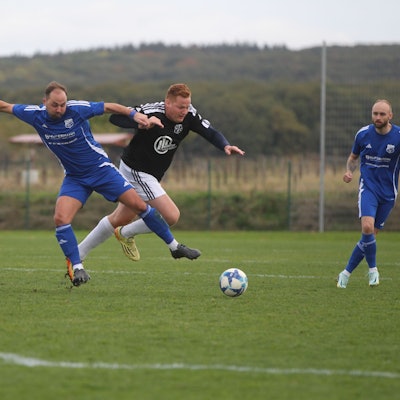 Zwei Fußballer kämpfen um den Ball.
