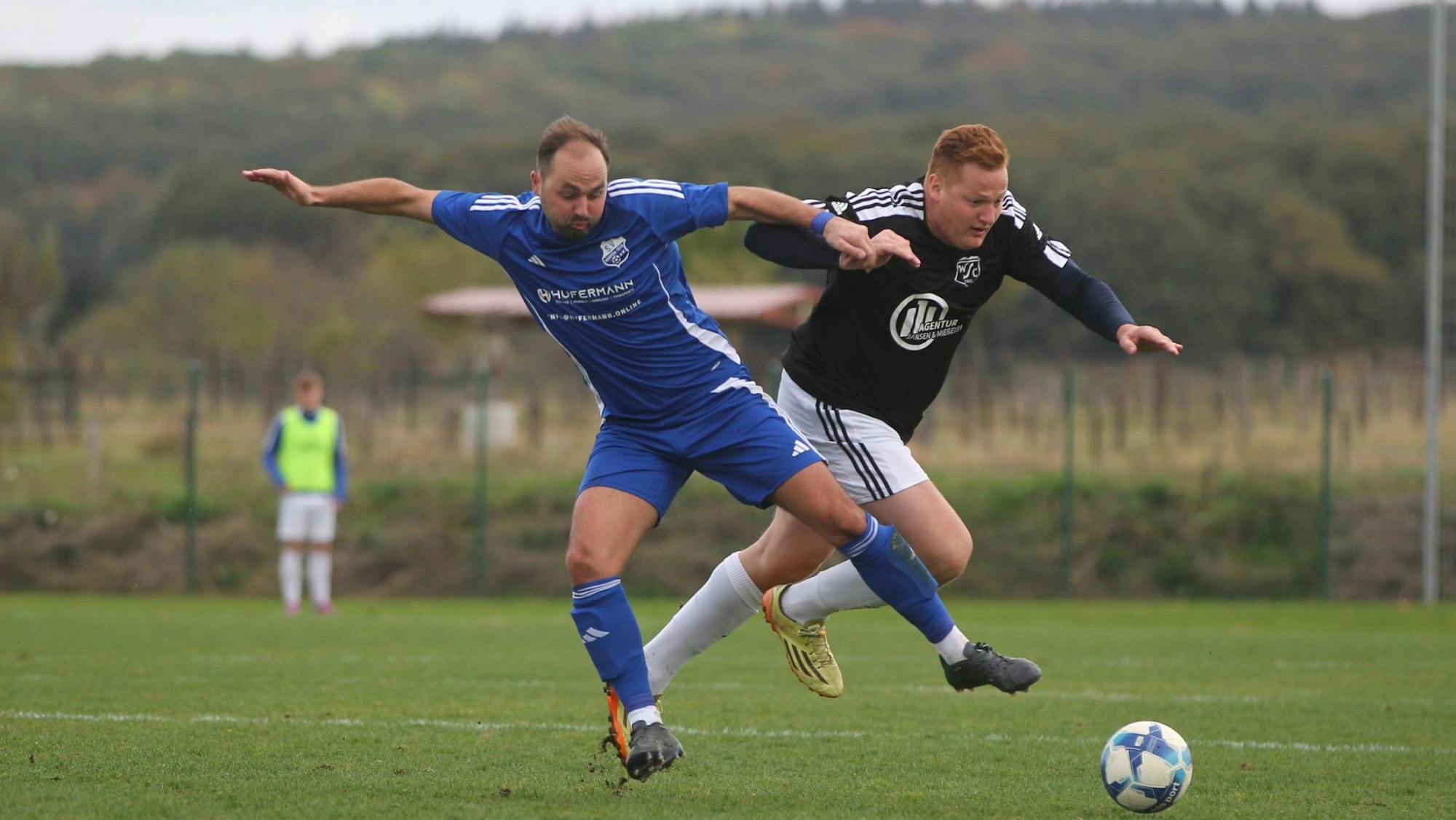Zwei Fußballer kämpfen um den Ball.