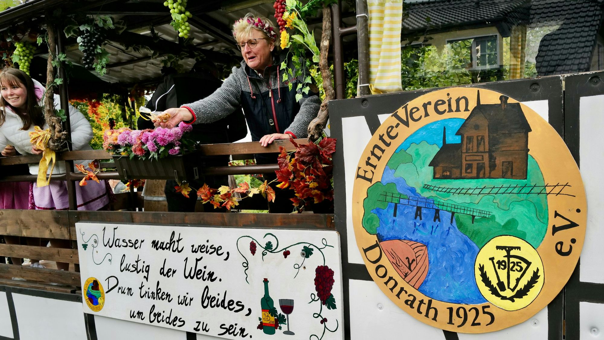 Zwei Frauen fahren auf einem geschmückten Wagen in einem Umzug.
