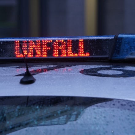 Der Schriftzug „Unfall“ ist neben dem Blaulicht auf dem Dach eines Polizeiautos zu lesen.
