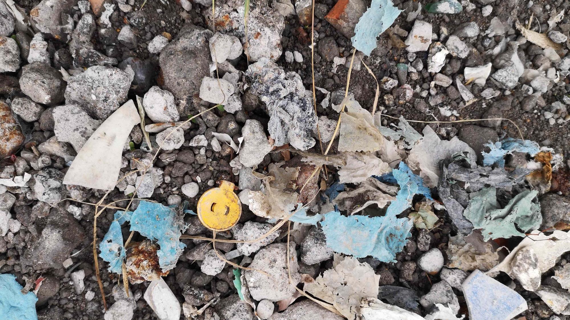 Zu sehen ist Plastikmüll in Recyclingbaumaterial.