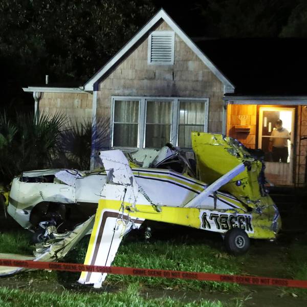 Ein Mann schaut aus der Eingangstür seines Hauses, nachdem eine Cessna in Savannah, Georgia, in den Vorgarten gestürzt ist.