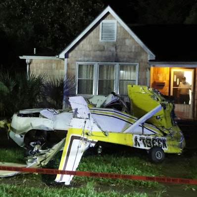 Ein Mann schaut aus der Eingangstür seines Hauses, nachdem eine Cessna in Savannah, Georgia, in den Vorgarten gestürzt ist.