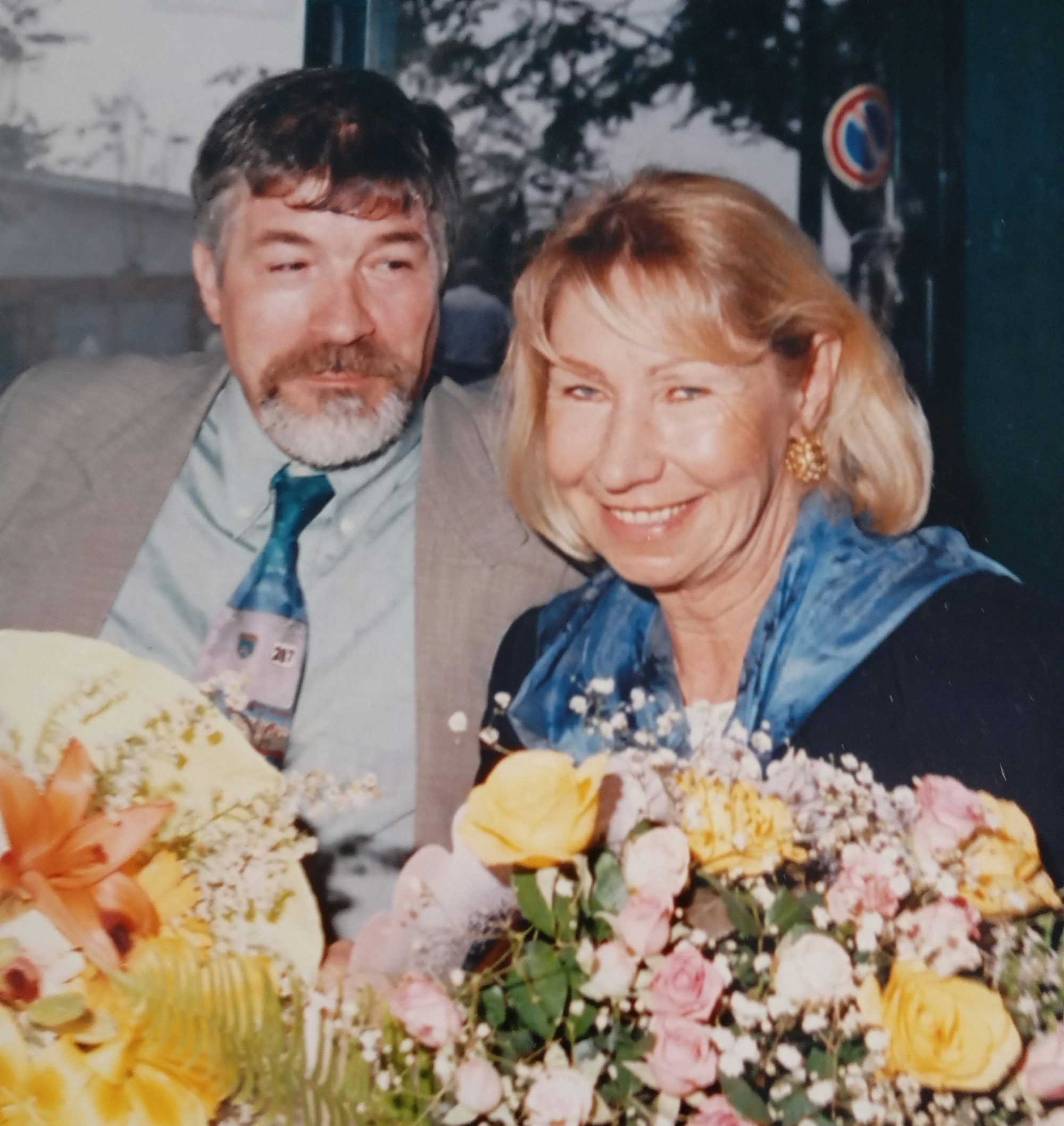 Das Bild zeigt ein Ehepaar mit Blumensträußen in den Händen.