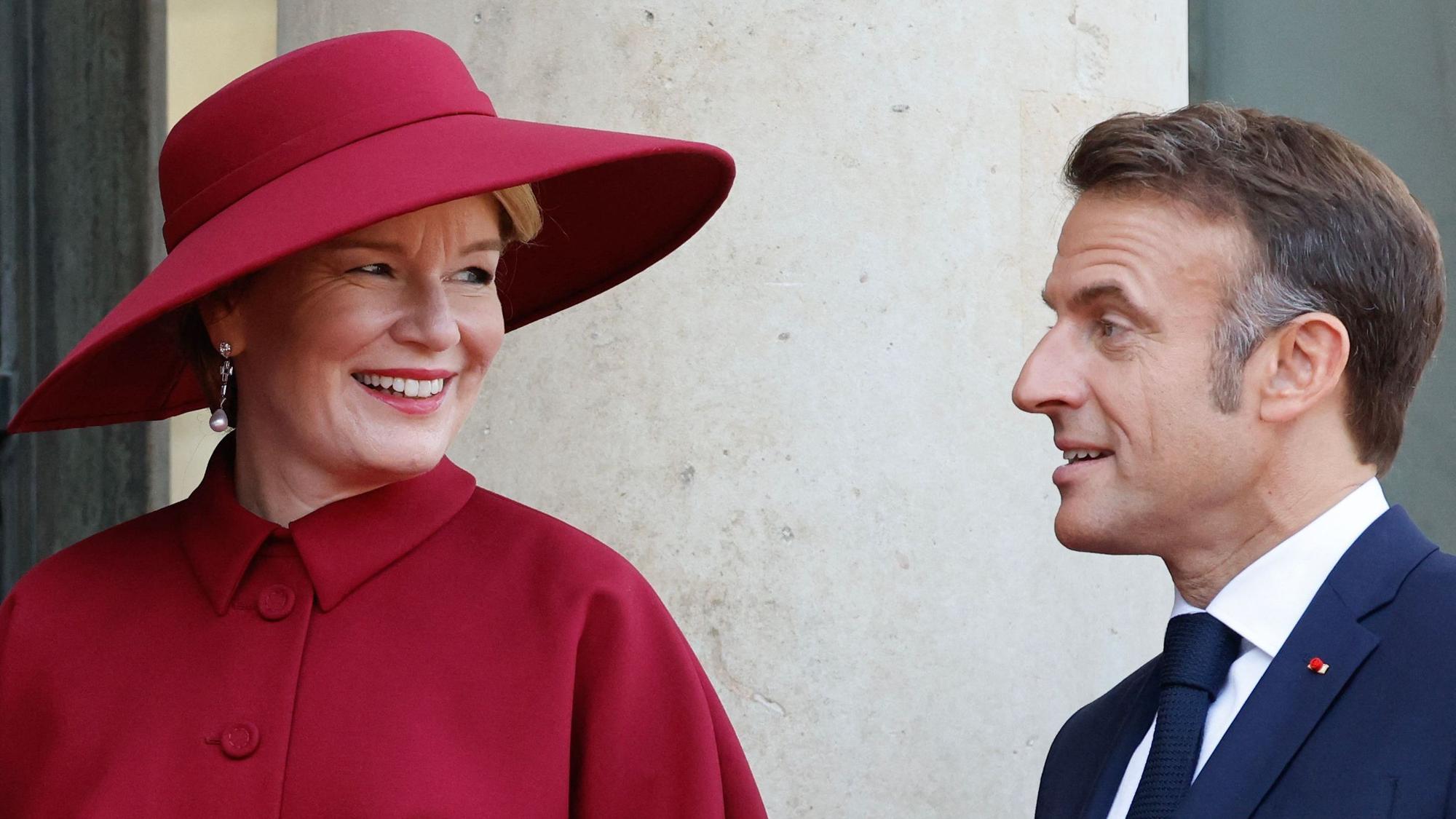 Der französische Präsident Emmanuel Macron (r) begrüßt Königin Mathilde von Belgien (l) bei ihrer Ankunft im Elyséepalast während des Staatsbesuchs in Paris.