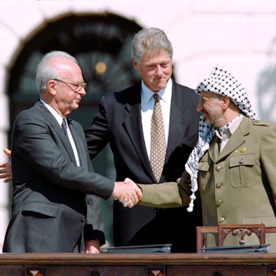 1993 schütteln sich der US-Präsident Bill Clinton, der PLO-Führer Yasser Arafat und der israelische Premierminister Yitzhak Rabin die Hand.