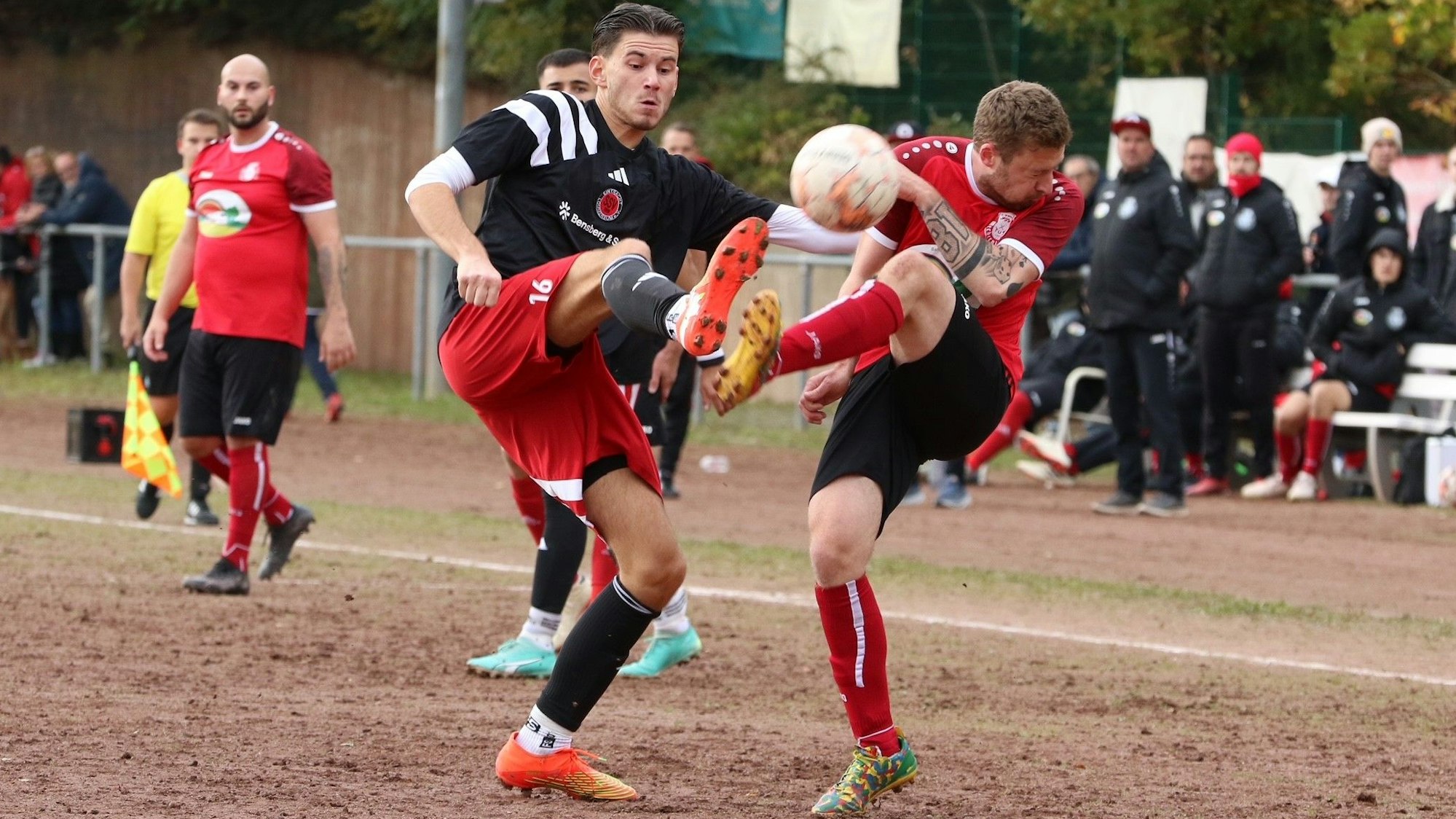 Das Bild zeigt die beiden Fußballer im Kampf um den Ball. Beide stehen nur mit einem Bein auf dem Boden.