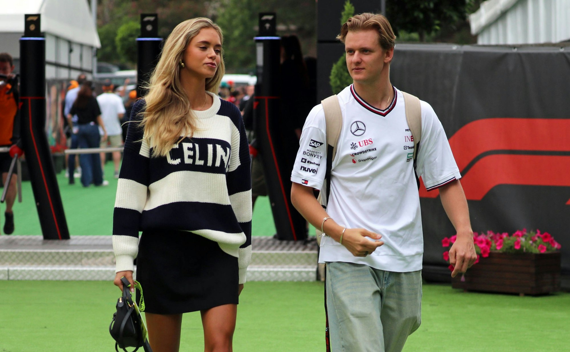 Mick Schumacher und seine Freundin Laila Hasanovic laufen durch das Fahrerlager in der Formel 1.