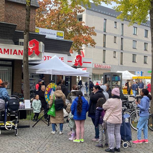 Menschen stehen während des Veedelsfestes auf dem Platz vor dem City Center Porz.