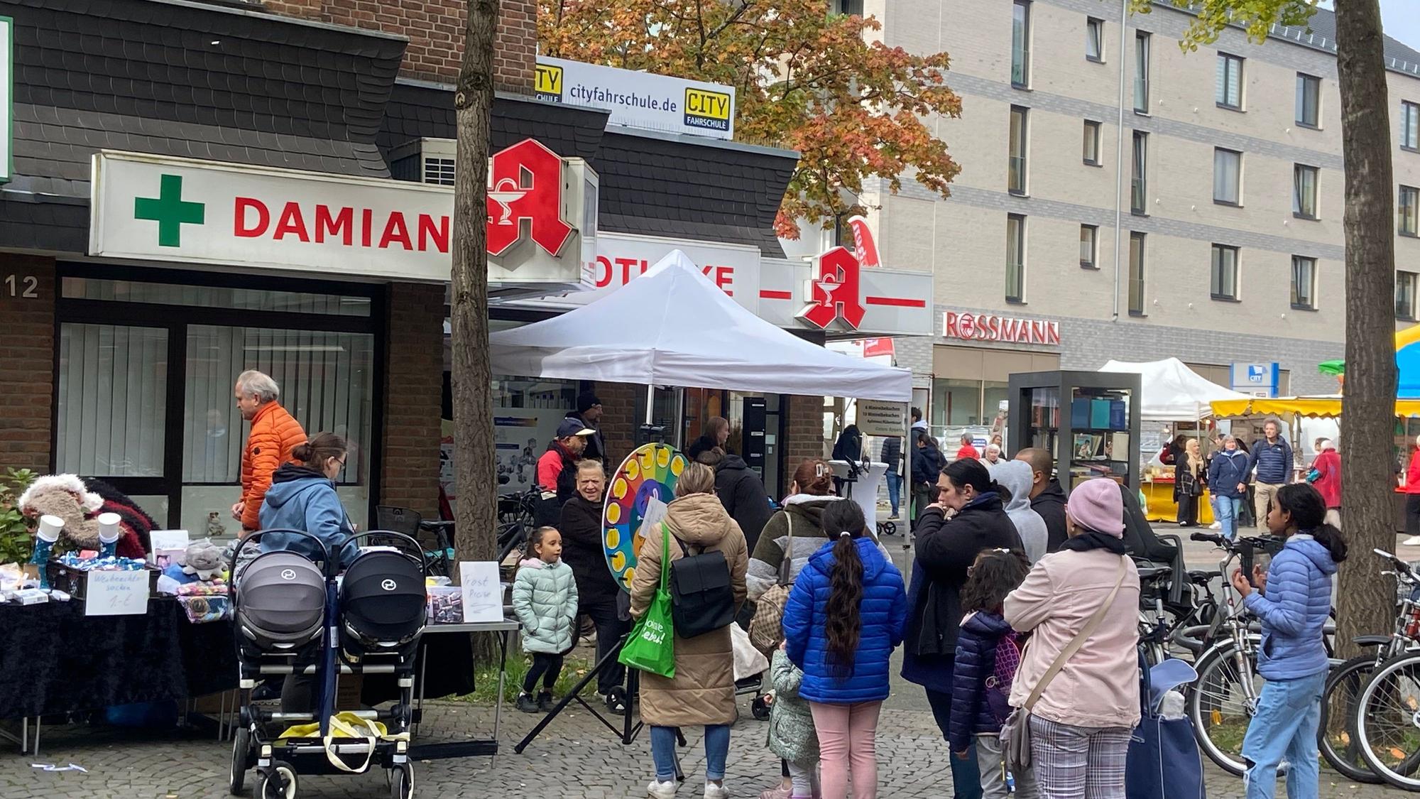 Menschen stehen während des Veedelsfestes auf dem Platz vor dem City Center Porz.