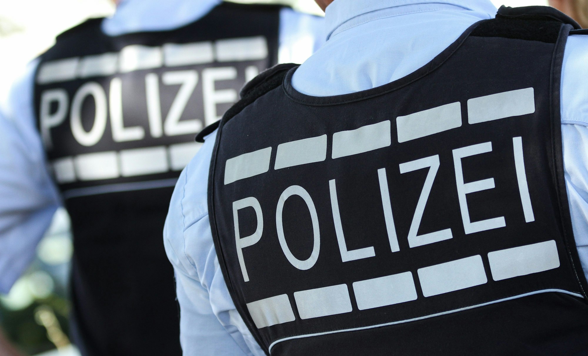 In Polizei-Westen gekleidete Polizisten stehen in der Stadt.