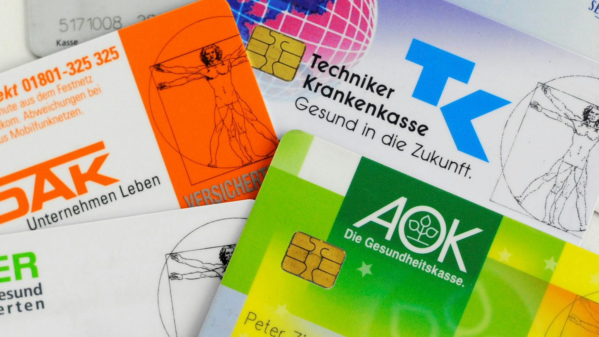 Krankenkassenkarten von gesetzlichen Krankenkassen liegen auf einem Tisch.