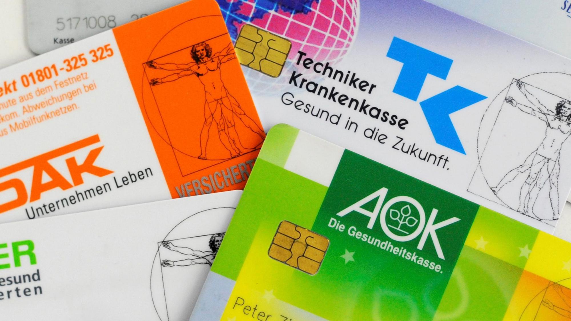 Krankenkassenkarten von gesetzlichen Krankenkassen liegen auf einem Tisch.