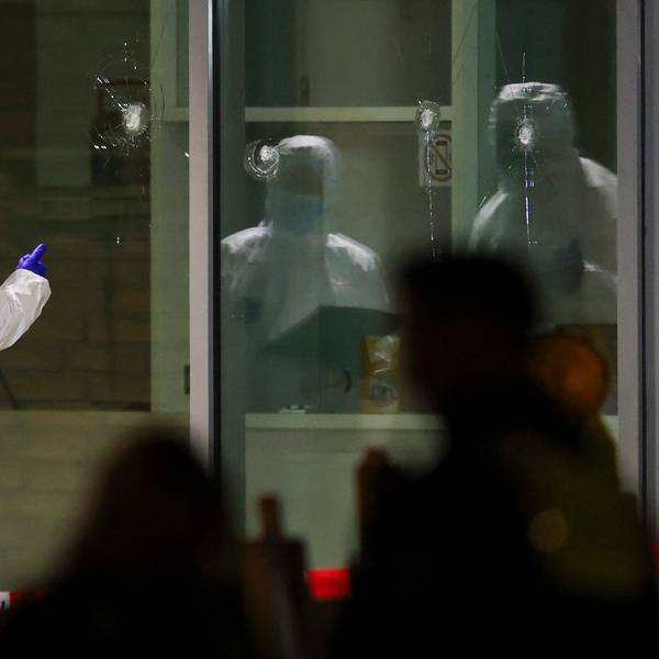 Polizeibeamte der Spurensicherung in weißen Schutzanzügen untersuchen Löcher in Glasscheiben des Kinos. Im Foyer eines großen Kinos am Hauptbahnhof in Krefeld hat die Polizei in der vergangenen Woche einen Brandstifter niedergeschossen.