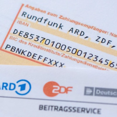 27.02.2024, Sachsen, Dresden: Ein Anschreiben zur Anmeldung für die Rundfunkgebühren liegt auf einem Überweisungsträger.