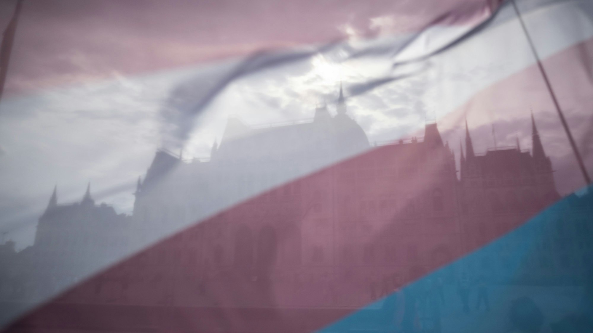 11.05.2024, Ungarn, Budapest: Das ungarische Parlamentsgebäude ist durch eine Transgender-Flagge während des Trans Pride Marsches zu sehen.