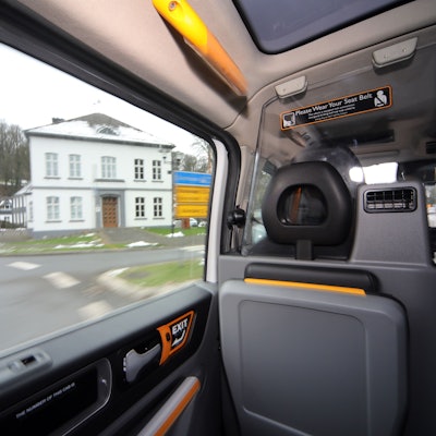 Durch das Fenster eines Sammeltaxis schaut man auf das Odenthaler Rathaus im Winter.