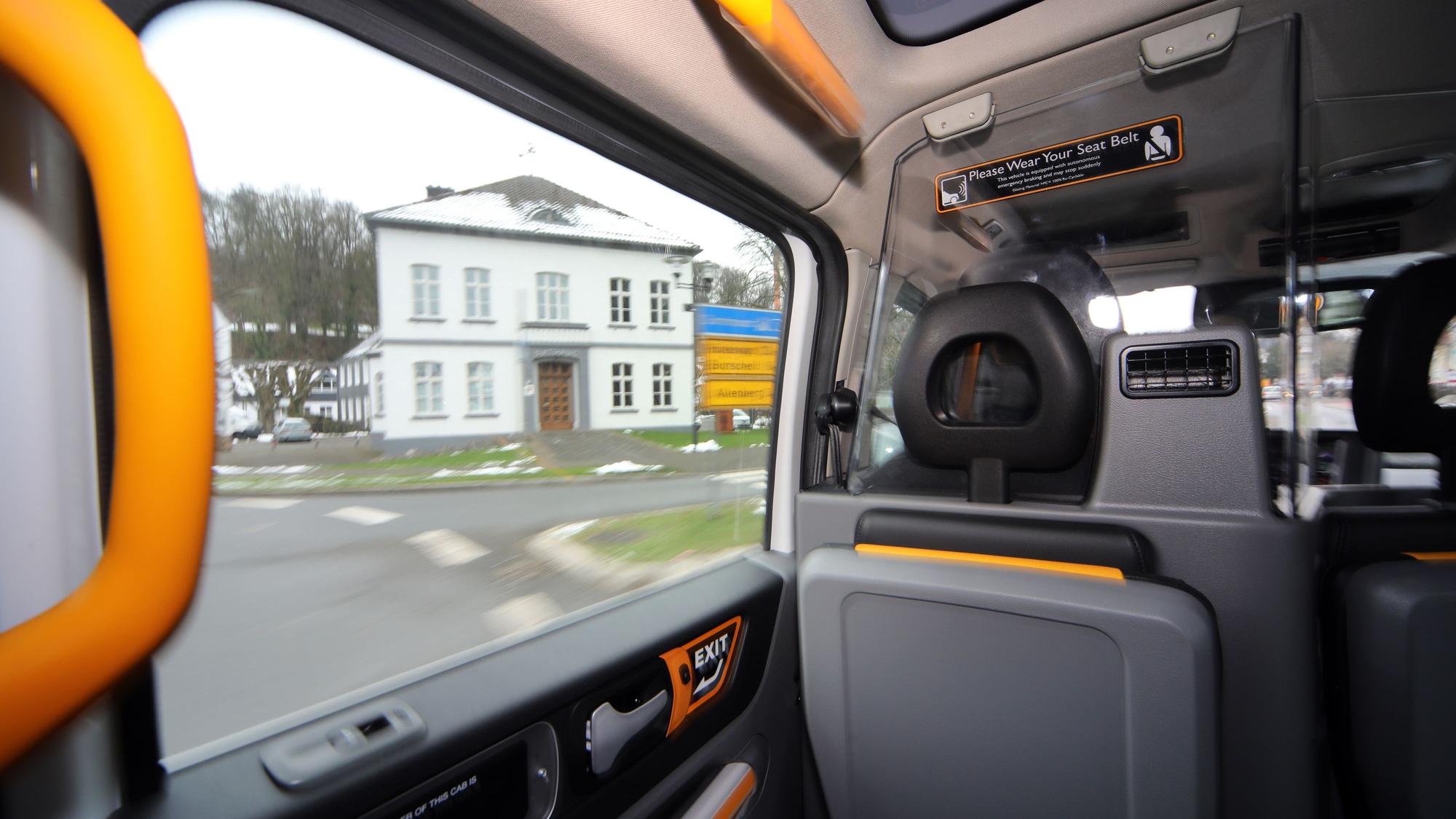 Durch das Fenster eines Sammeltaxis schaut man auf das Odenthaler Rathaus im Winter.