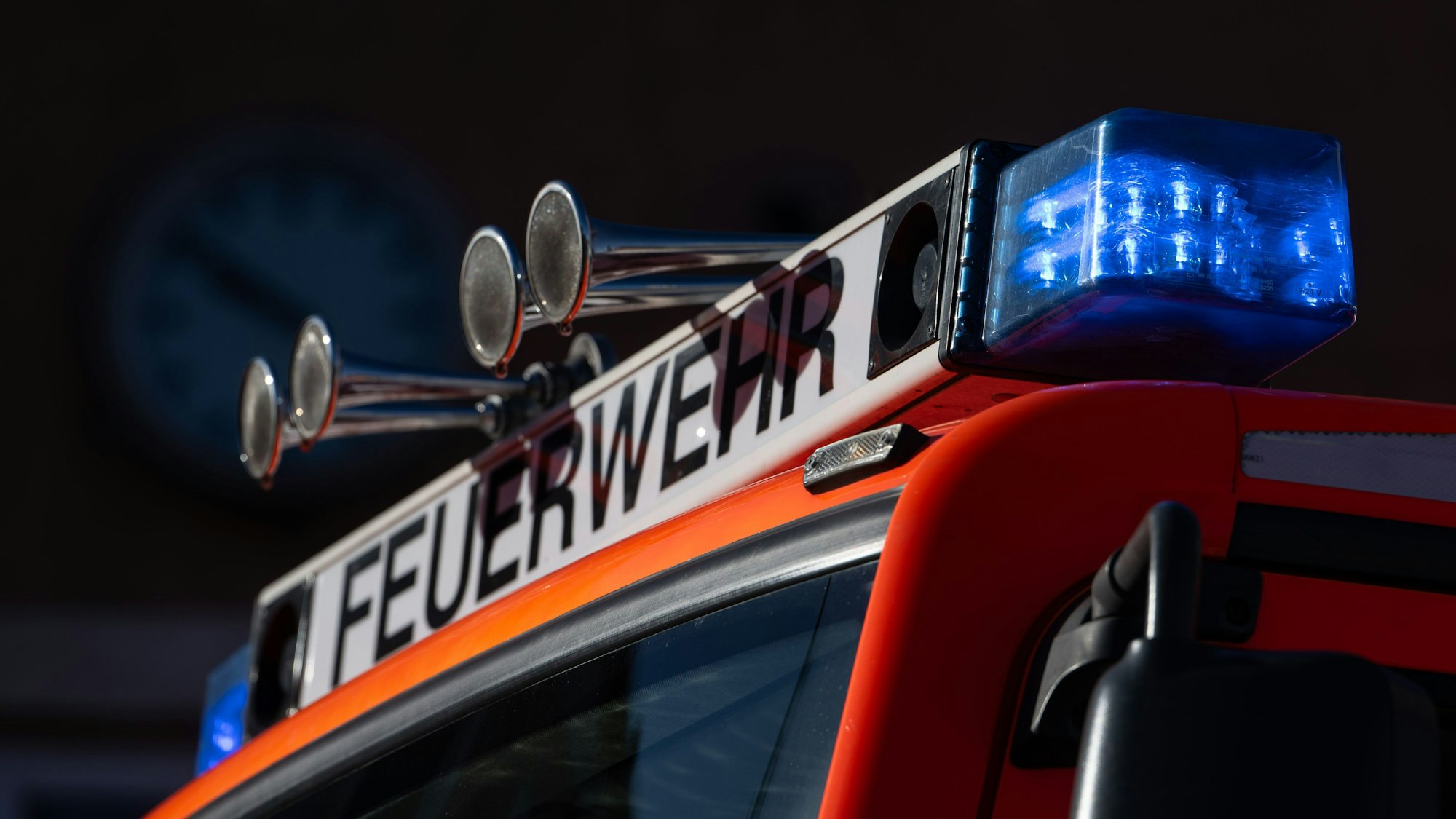 Ein Einsatzfahrzeug der Feuerwehr mit eingeschaltetem Blaulicht.