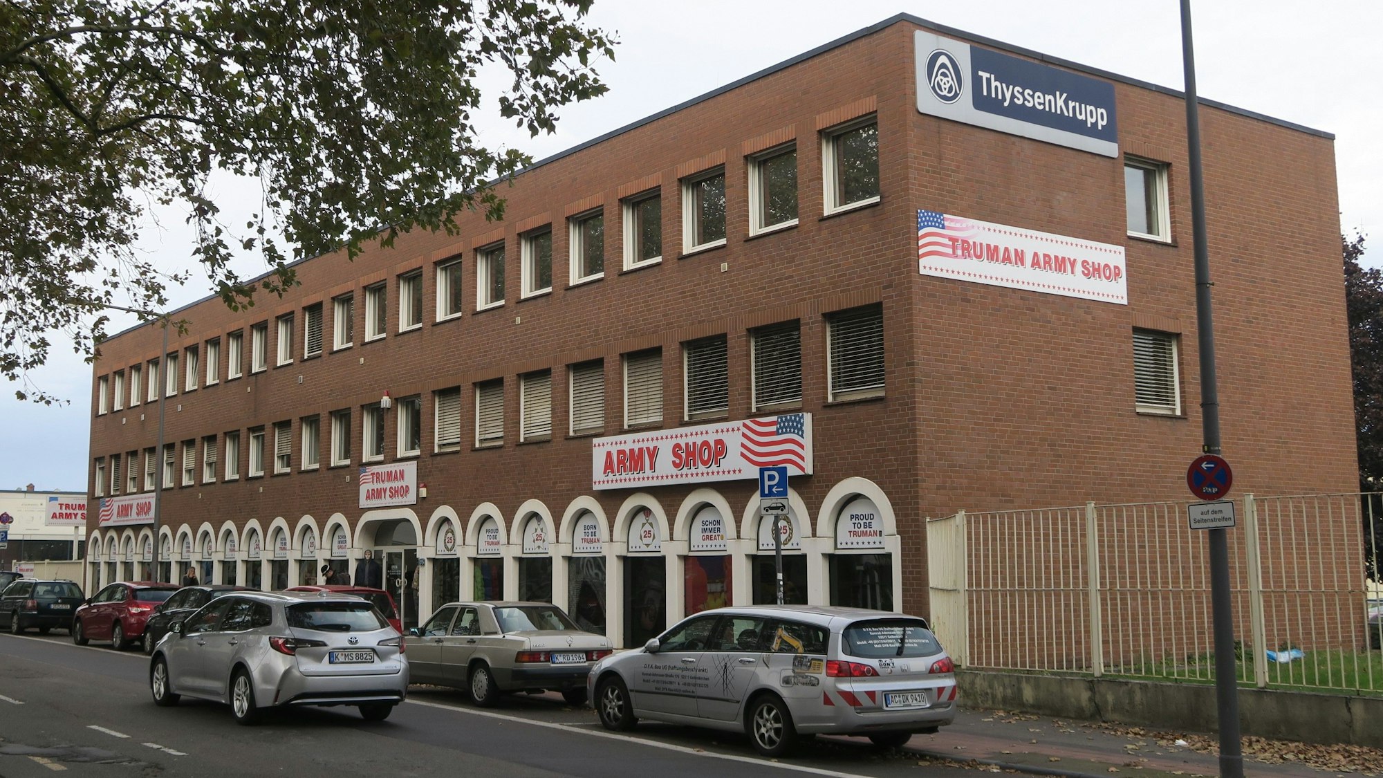 Zu sehen ist ein rechteckiges Backsteingebäude mit Firmenwerbung auf der Fassade.