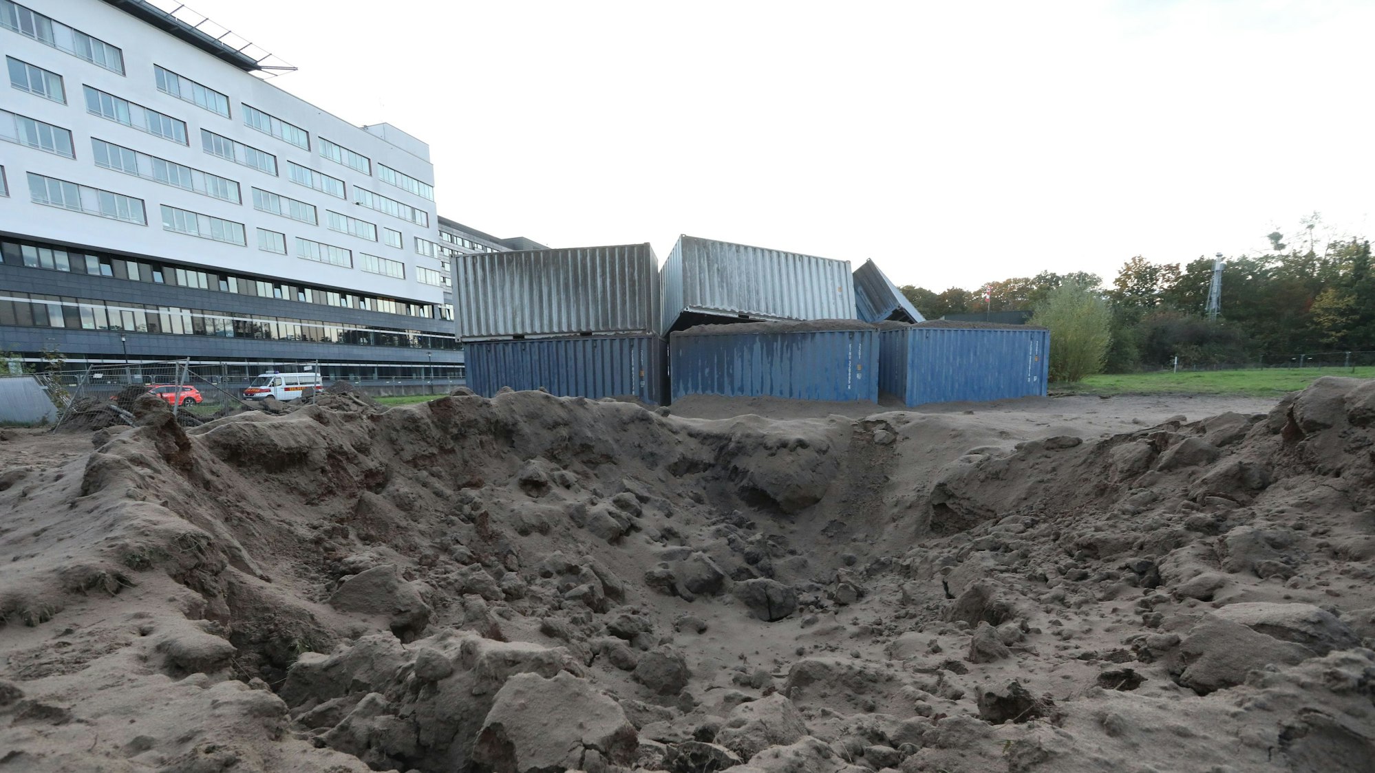 Die Wucht der kontrollierten Sprengung warf die Container um und hinterließ einen Krater vor dem Krankenhaus in Merheim.