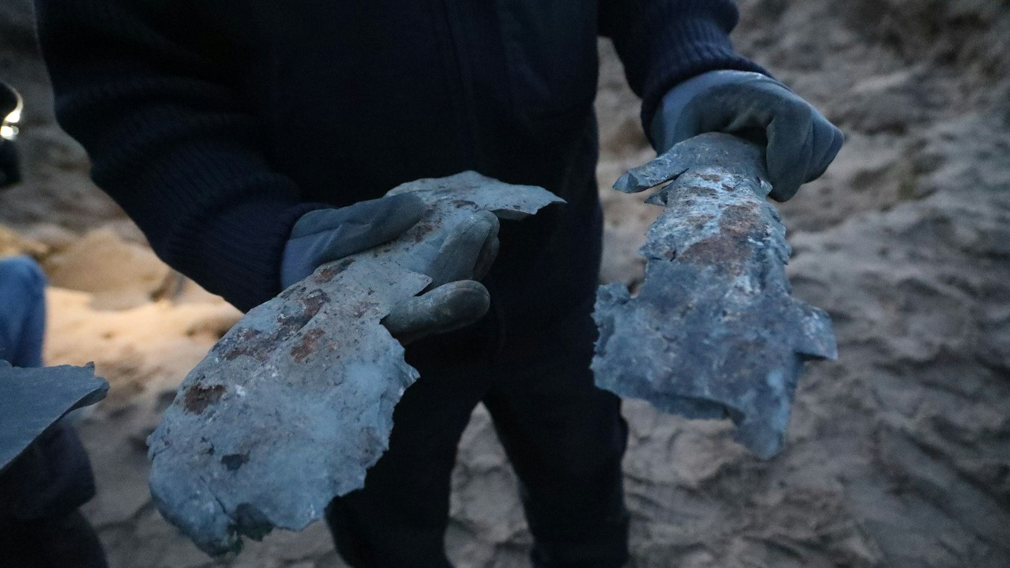 Ein Entschärfer hält die Reste der gesprengten Bombe in der Hand.