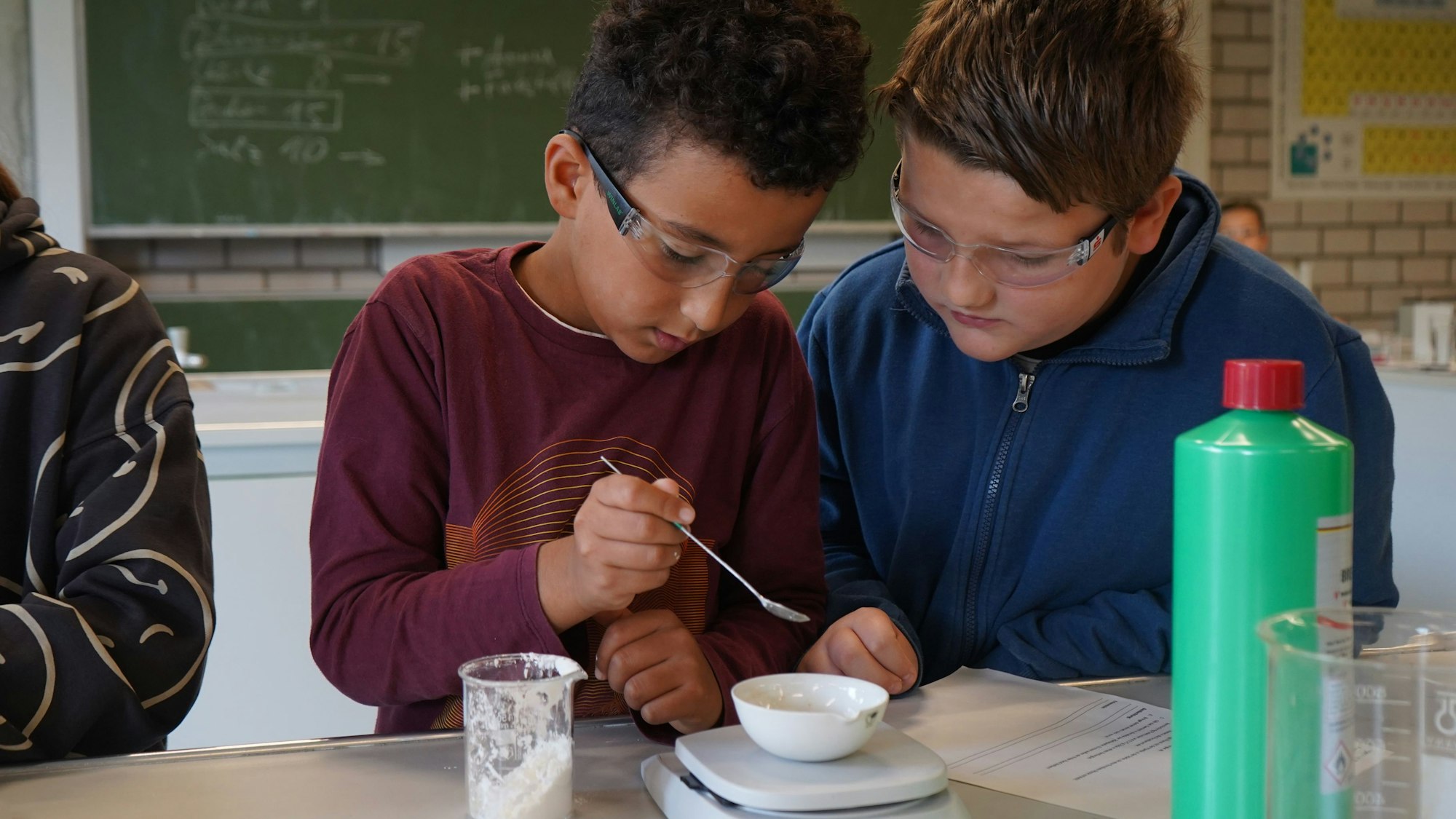 Das Foto zeigt zwei Kinder beim Abwiegen einer weißen Substanz.