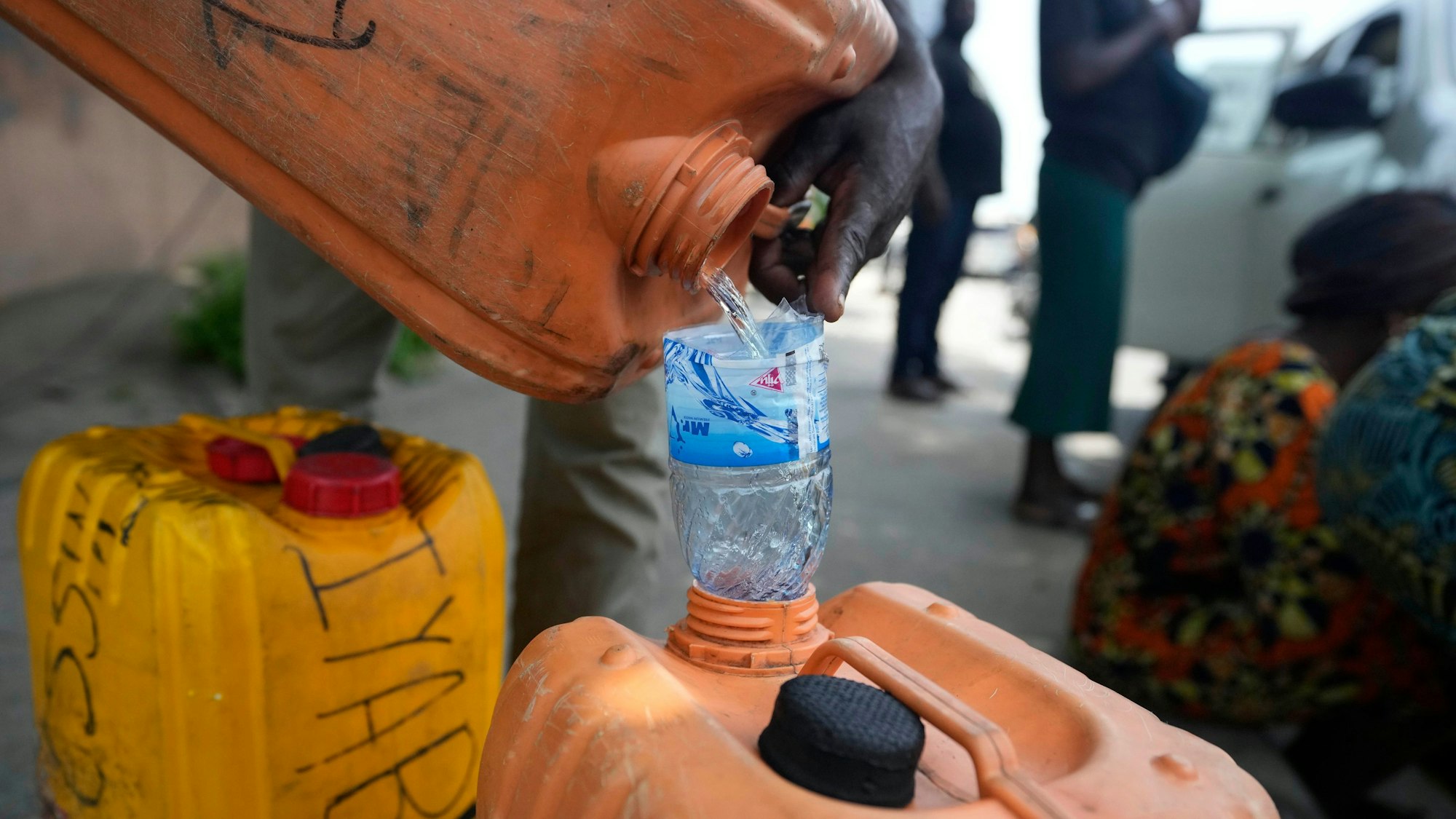 ARCHIV - 30.04.2024, Nigeria, Lagos: ILLUSTRATION - Ein Mann verkauft Kraftstoff in der Nähe einer Tankstelle in Nigeria. (zu dpa: «Mindestens 94 Tote nach Explosion von Tanklaster in Nigeria») Foto: Sunday Alamba/AP/dpa +++ dpa-Bildfunk +++