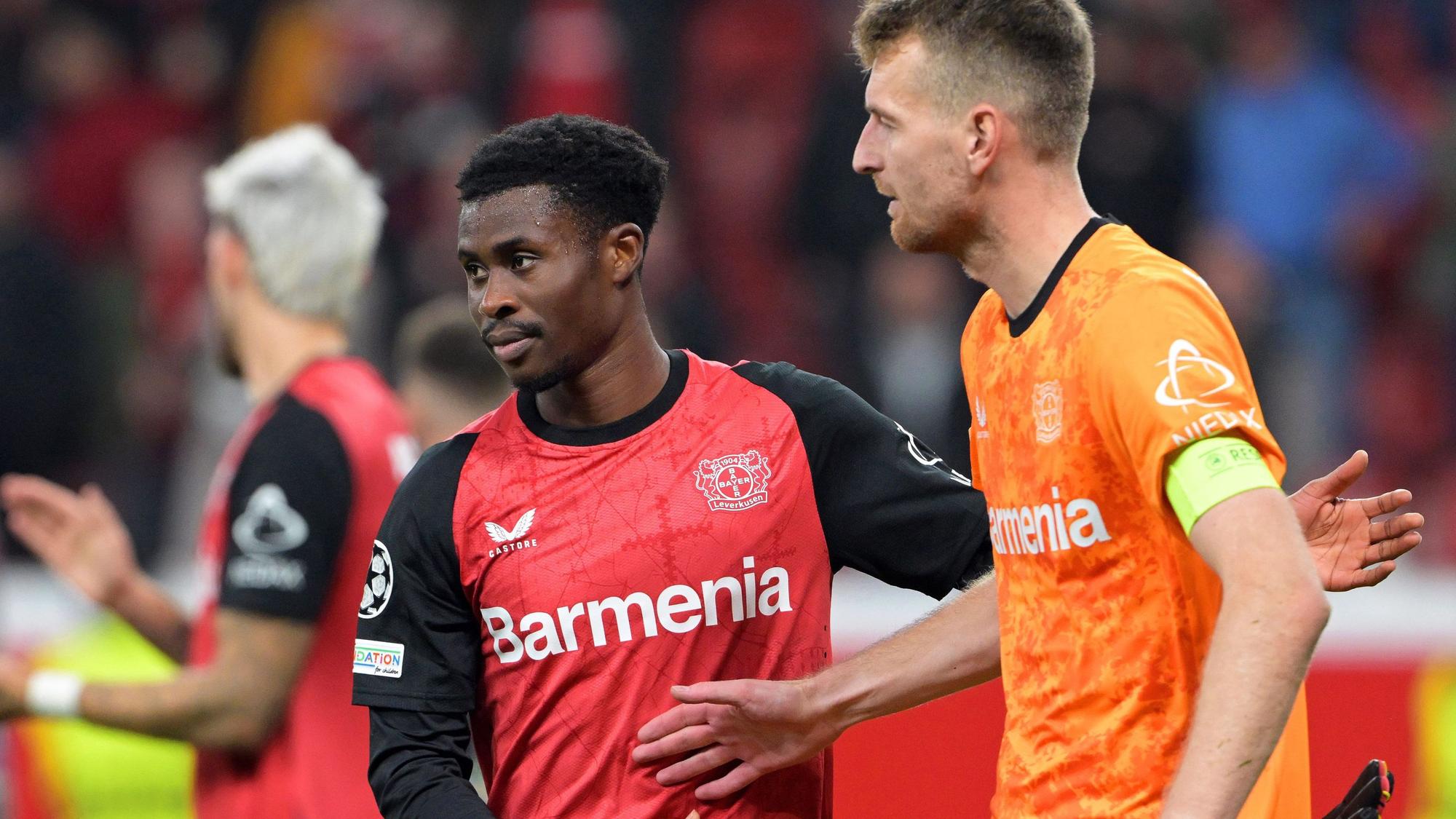 Leverkusens Spieler Nathan Tella (M) und Torhüter Lukas Hradecky (r) nach dem Spiel gegen Mailand.