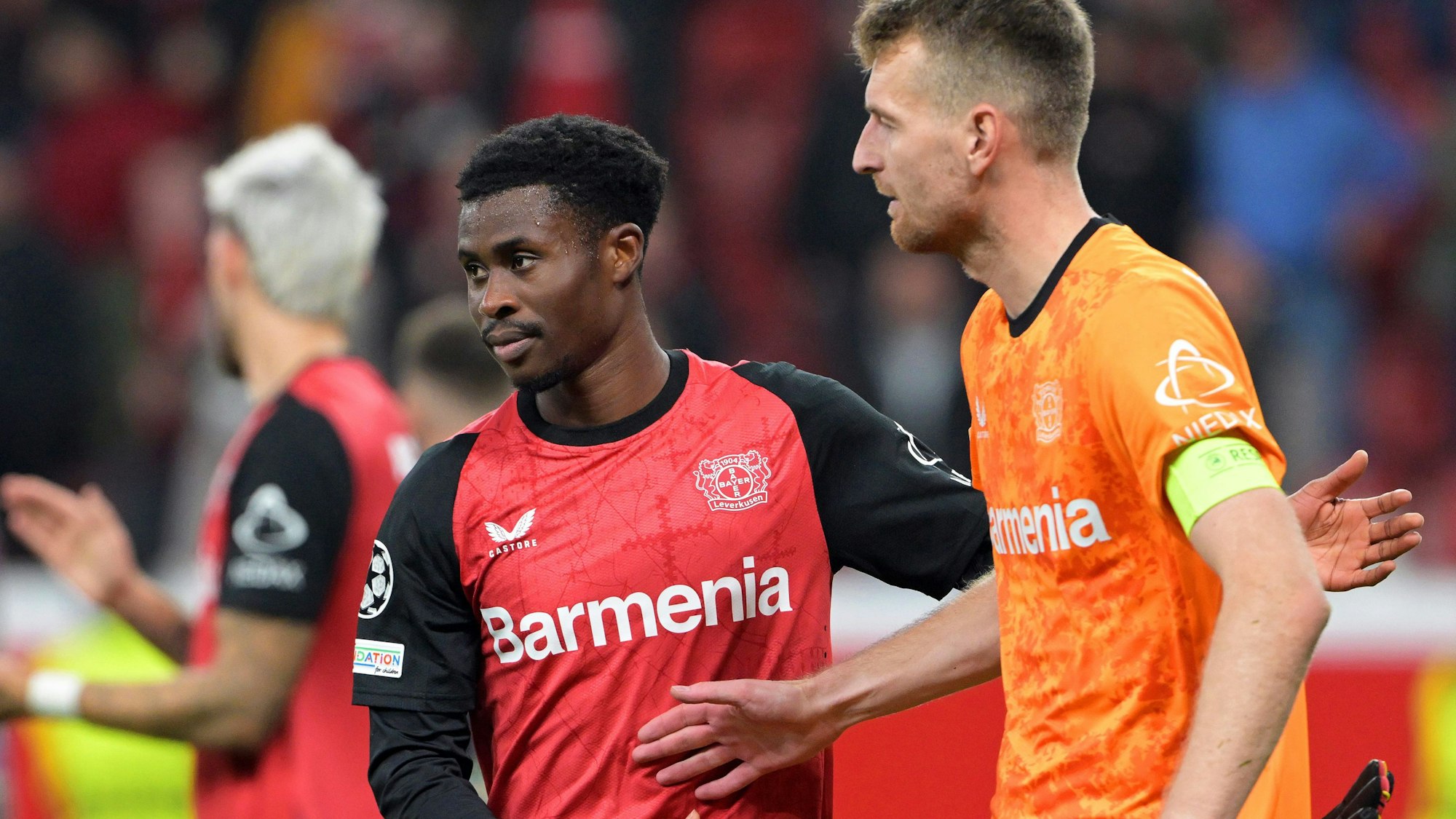 Leverkusens Spieler Nathan Tella (M) und Torhüter Lukas Hradecky (r) nach dem Spiel gegen Mailand.