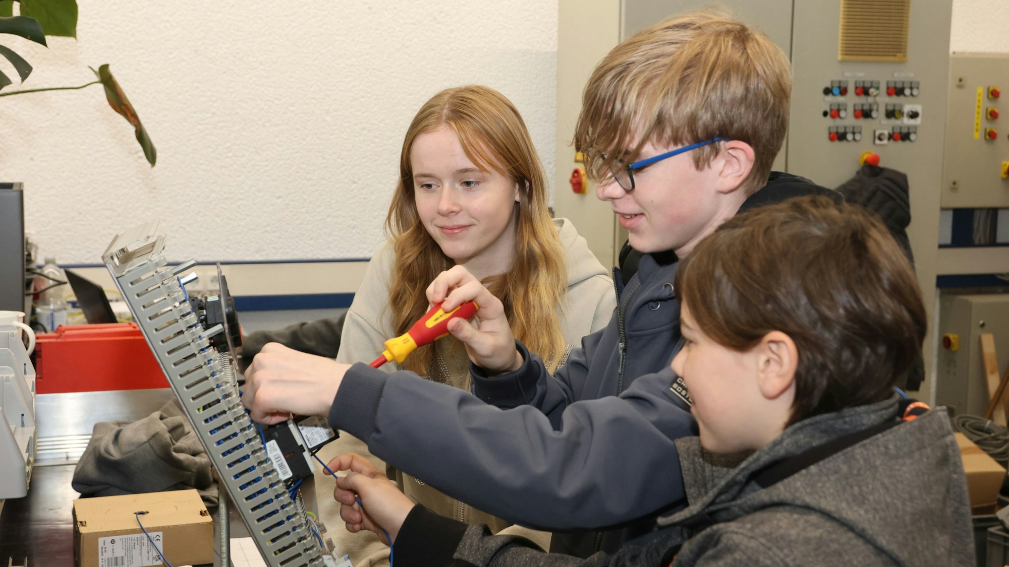 Drei Jugendliche verdrahten bei Unitechnik unter anderem eine Schützschaltung.