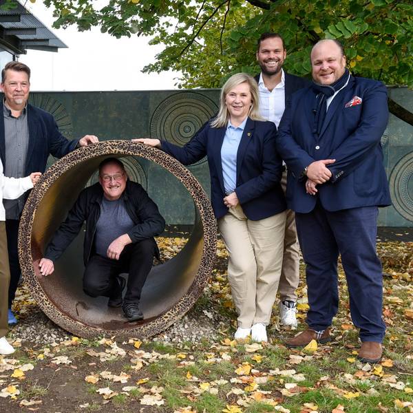 Auf dem Bild ist die Übergabe des Steinzeugrohrs zu sehen.