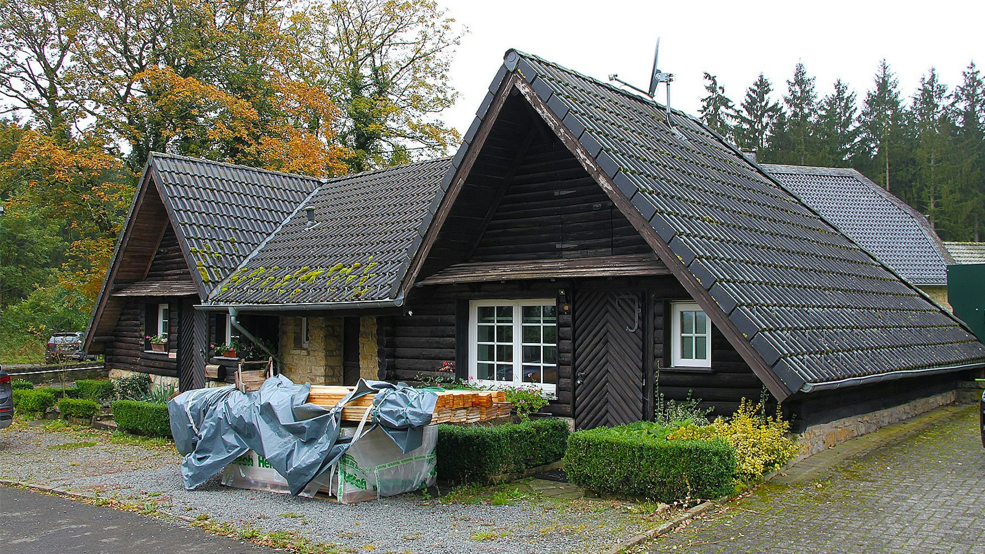 In zwei kleinen,aus dunklem Holz gebauten Spitzdachhäuschen wird ein Café eingerichtet.