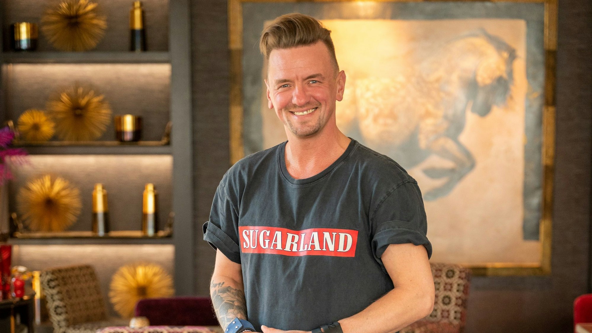 Zu sehen ist der Sänger Ben Zucker, der in die Kamera lächelt.