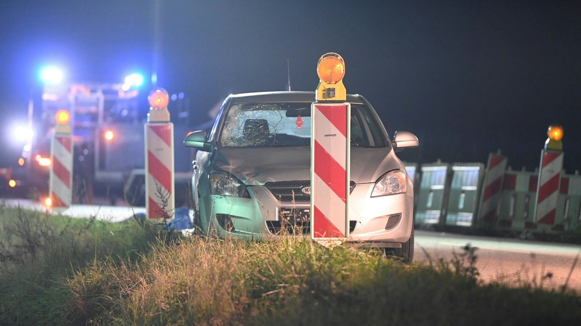 Ein silbernes Auto mit einer gesplitterten Frontscheibe steht neben Absperrbaken.